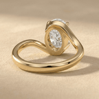 Oval moissanite ring with curved bypass gold band