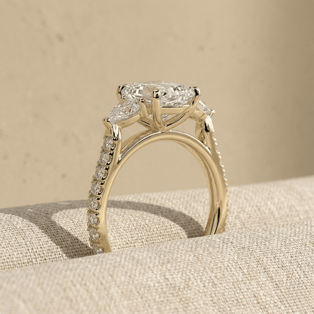 Three stone pear moissanite ring with elegant gold setting