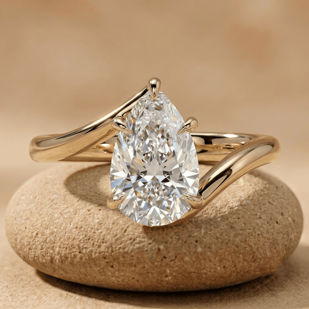 Pear cut moissanite solitaire bypass engagement ring in 18K yellow gold