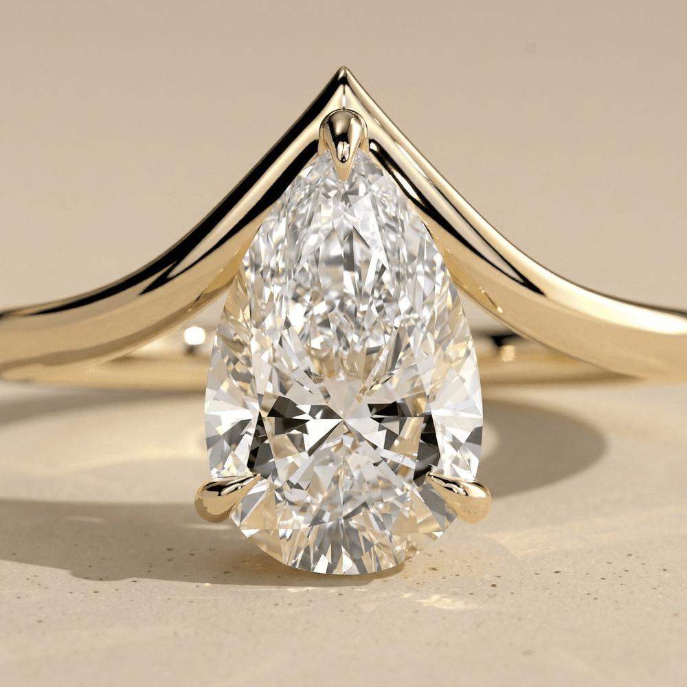 Curved gold engagement ring with pear shaped center moissanite close up
